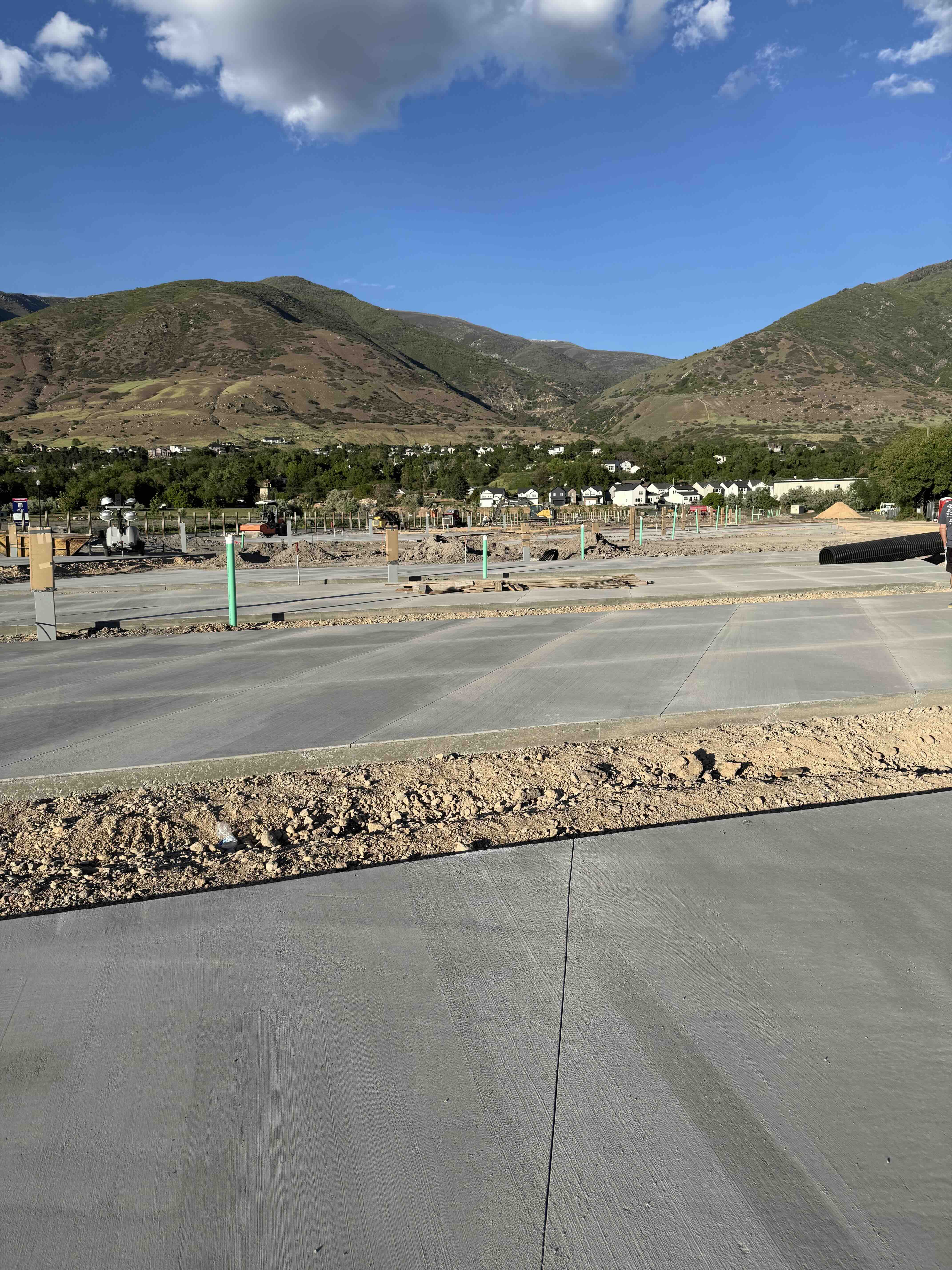 Spring Creek RV Resort — fresh concrete RV pads under construction with stunning Wasatch mountain backdrop, Farmington Utah