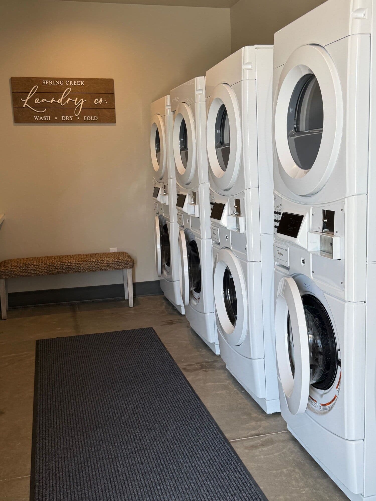 Laundry room with stacked commercial washers and dryers