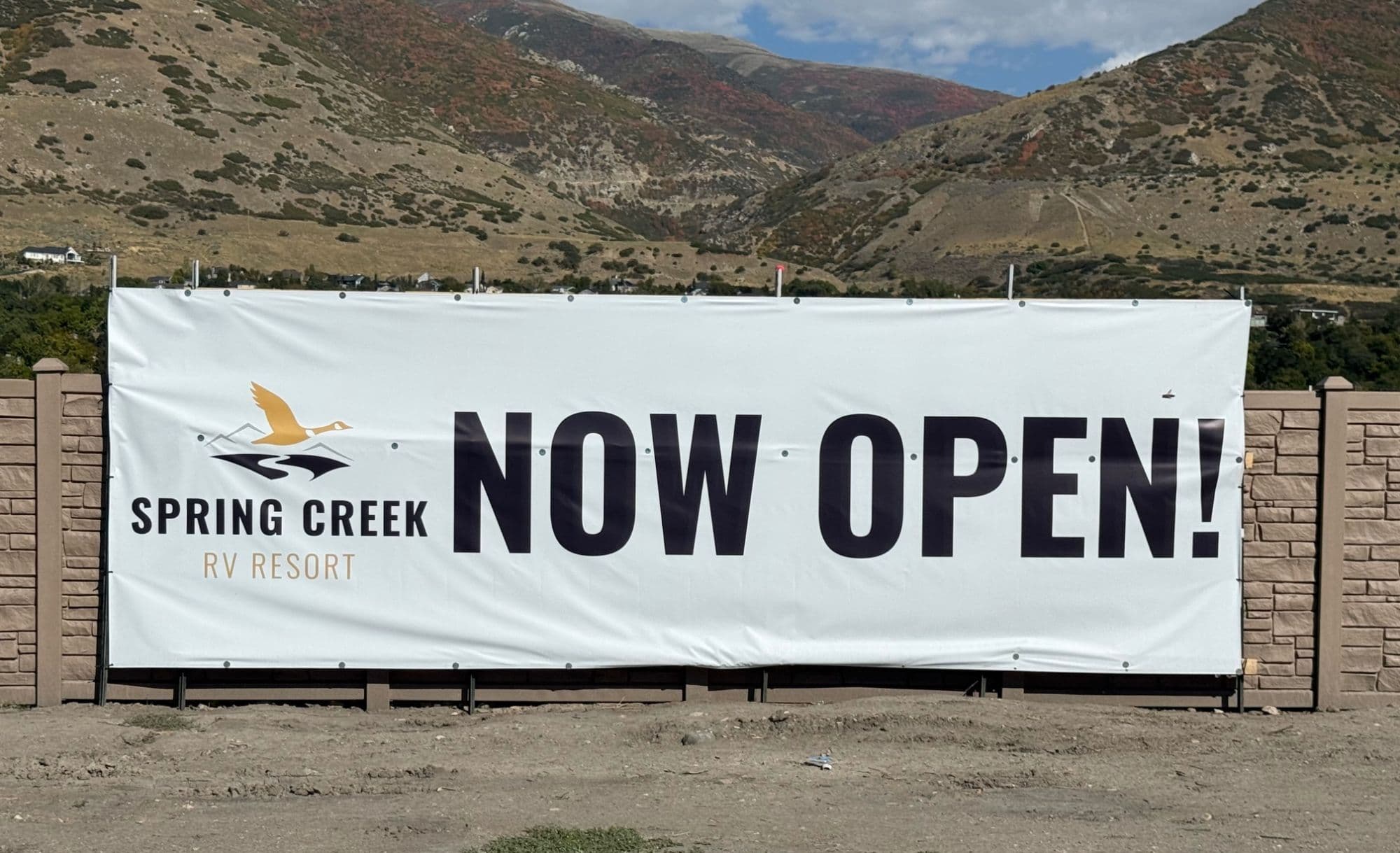 Spring Creek RV Resort Now Open banner with the Wasatch mountains in fall color