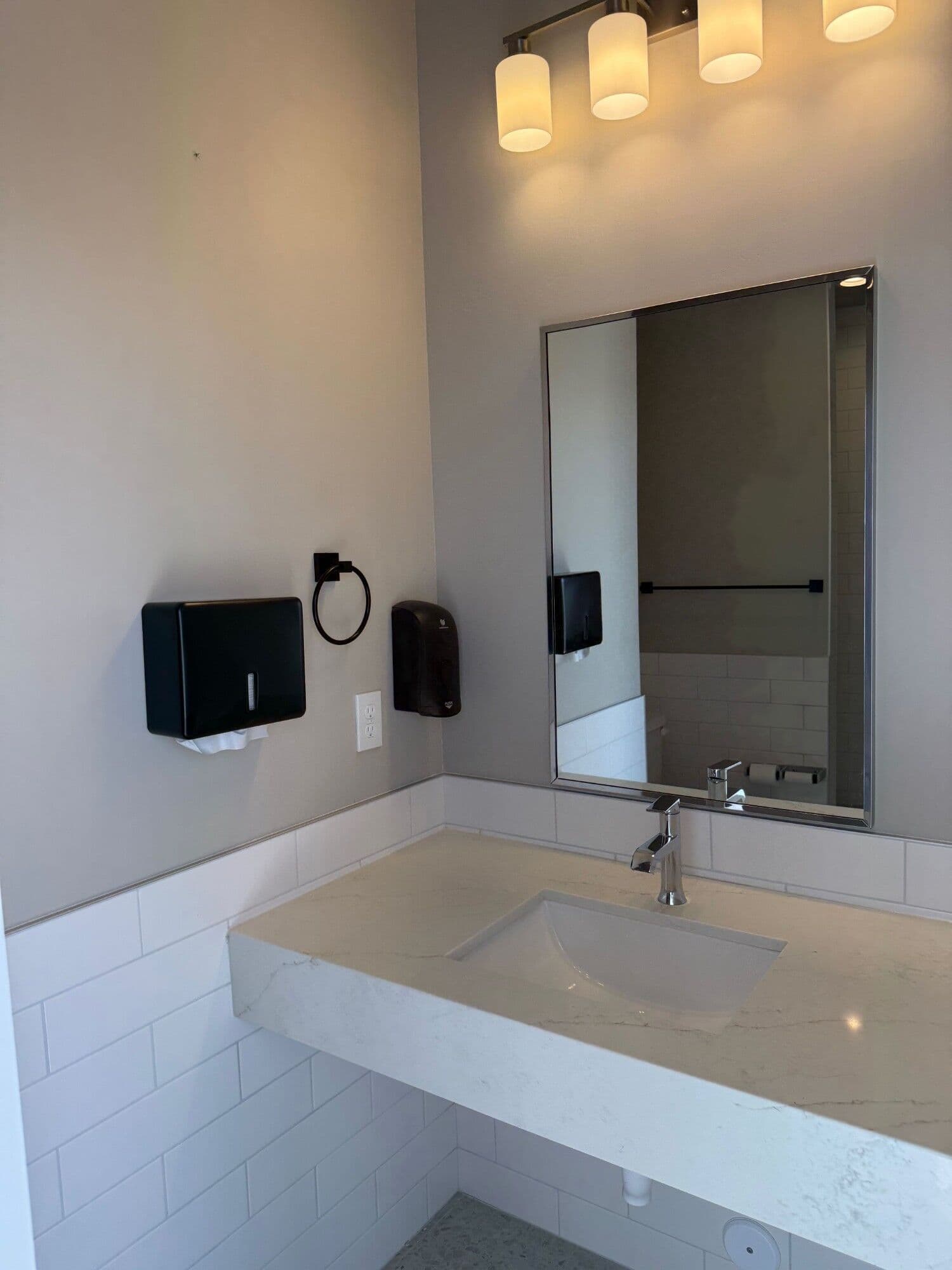 Restroom vanity with quartz countertop and framed mirror