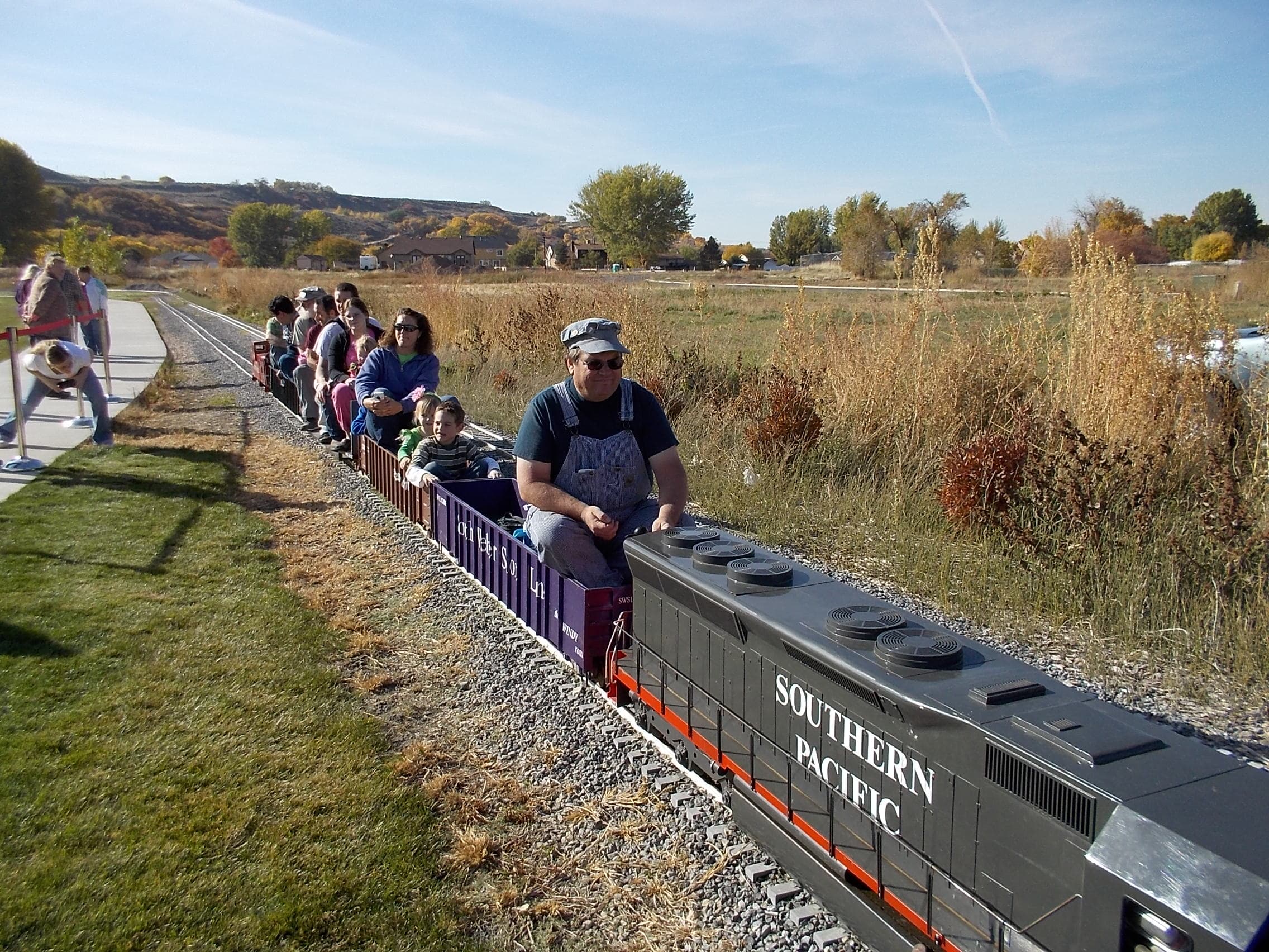 Families riding the outdoor model railroad at South Weber, Utah